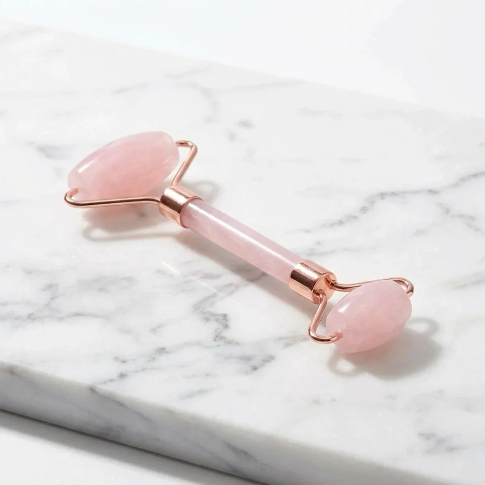 Beauty product image: rose quartz face roller on white marble