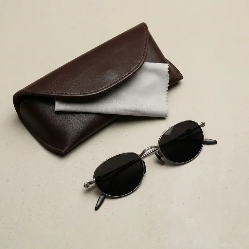 Accessories lifestyle image: card holder sunglasses flat lay